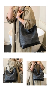 Detail view of large capacity tote bag featuring grey marble texture and black leather straps