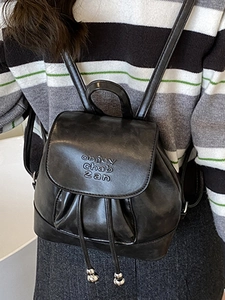 Fashionable black PU leather drawstring backpack with flap closure and embossed text design