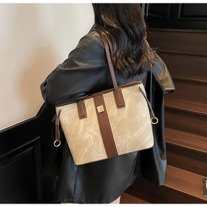 Détail du sac cabas gris avec cordons latéraux et finitions en cuir marron contrastées