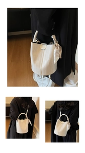 Vue détaillée du sac seau tressé blanc avec logo fashion et foulard décoratif sur la poignée