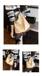 Detail of large beige canvas and brown leather hobo shoulder bag shown on a model