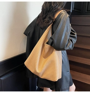 Vue détaillée de la texture en cuir tissé marron sur un grand sac cabas élégant