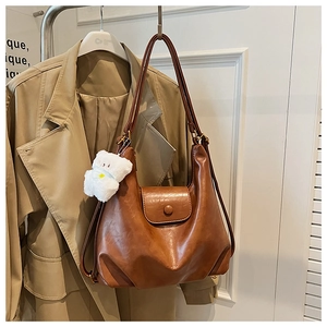 Gros plan d'un sac cabas marron vintage avec un adorable pendentif ours en peluche