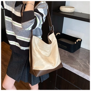 Detail of contrast beige and brown large capacity PU leather tote bag with wide strap