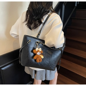 Détail du grand cabas noir en similicuir avec un charmant pendentif ours en peluche marron