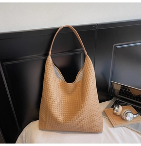 Grand sac hobo tressé beige avec un intérieur spacieux et une bandoulière large très élégante