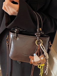 Borsa a tracolla in pelle cerata marrone caffè con ciondolo a forma di orsetto