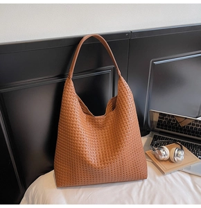 Gros plan détaillé sur la texture tressée du grand sac hobo marron caramel chic
