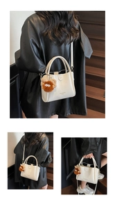 Multiple views of a white lychee leather tote bag with a cute brown plush monster charm