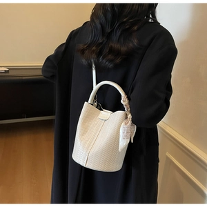 Détails du sac seau blanc tressé avec foulard en soie et logo FASHION décoratif