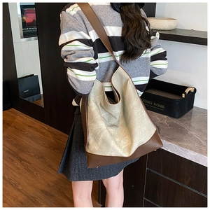 Close-up of a large capacity two-tone tote bag with grey texture and brown leather straps