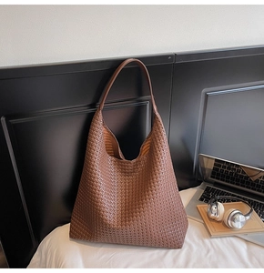 Détail d'un grand sac hobo tressé marron montrant la texture et la capacité de rangement