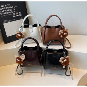 Close-up of four lychee texture leather handbags in white, brown, burgundy, and black colors