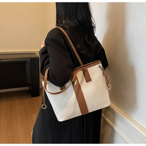 Sac fourre-tout chic bicolore porté à l'épaule montrant la taille et les détails dorés