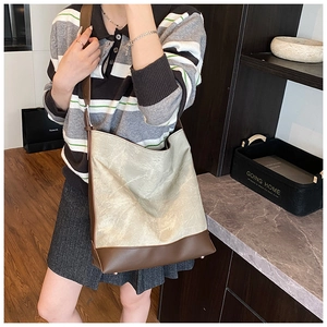 Detail of vintage tote bag showing beige pleated texture and brown leather strap contrast
