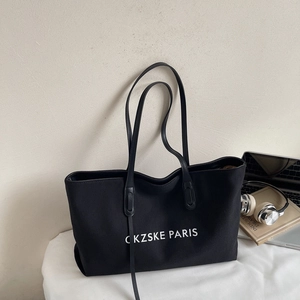 Vue détaillée du grand sac cabas noir en toile avec texte CKZSKE PARIS et anses en cuir
