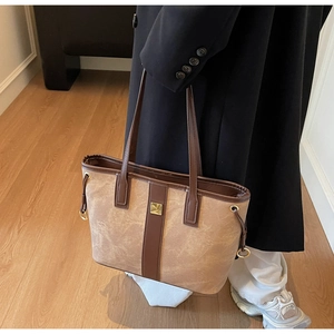 Détail du cabas vintage marron avec cordons de serrage et boucle en métal doré