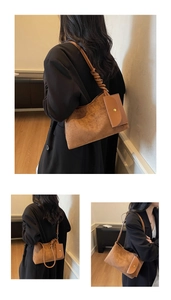 Dettaglio borsa sottobraccio in pelle scamosciata caramello con tracolla annodata e mini pouch