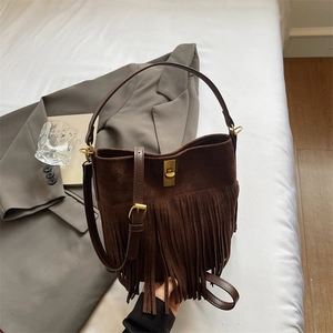 Detail of bohemian dark brown suede fringe bag featuring a vintage gold twist lock