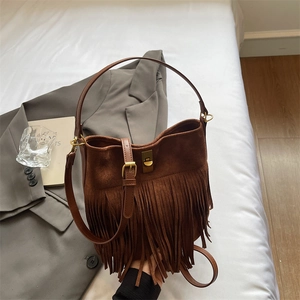 Close-up of vintage brown suede bucket bag with long fringe tassels and golden buckle