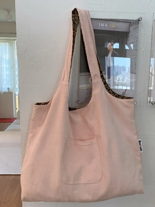 Pink canvas tote bag with leopard print lining and Merci Lable on minimalist white wall