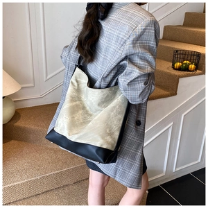 Detail view of large tote bag in marble textured PU leather with black base on a model