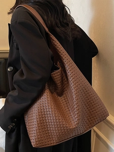 Grand sac cabas tressé marron pour femme porté par un mannequin pour un look décontracté