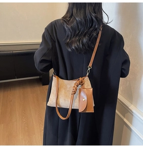 Dettaglio della borsa tote in camoscio beige con tracolla in pelle e mini pochette a busta