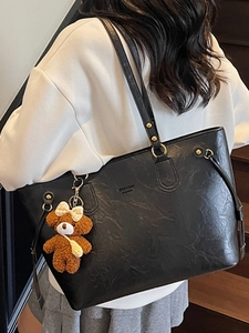 Sac fourre-tout minimaliste en similicuir noir avec boucles dorées et breloque ourson