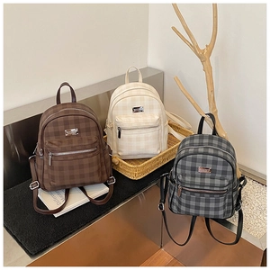 Detail showing checkered casual backpacks in coffee, beige, and grey with metallic logos