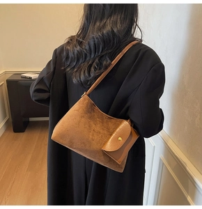 Dettaglio della borsa tote in pelle scamosciata marrone con piccola tasca funzionale