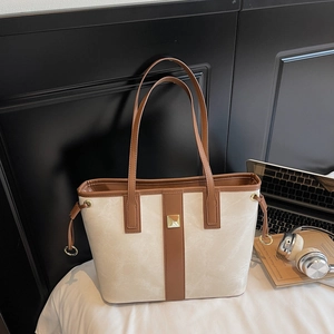 Détails du grand sac cabas beige et marron avec logo en métal et ordinateur portable