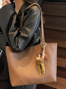 Brown large capacity leather tote bag with cute bear charm and minimalist trapezoidal design