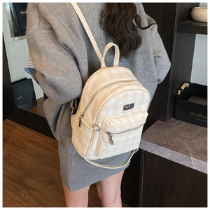 Detail of checkered mini backpack in beige leather with zip pockets and metal logo