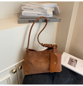 Dettaglio della borsa tote in pelle scamosciata marrone con mini pochette e tracolla intrecciata