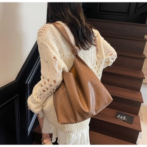 Détail du grand sac cabas en cuir marron souple avec un nœud stylé sur la bandoulière