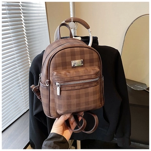 Detail showing brown checkered pattern on small synthetic leather backpack