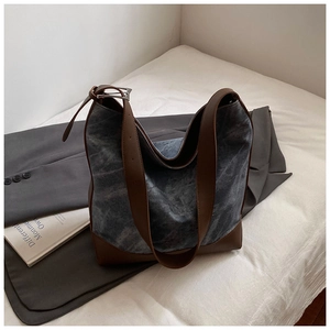 Detailed close-up of retro large-capacity hobo tote bag with canvas and leather trim