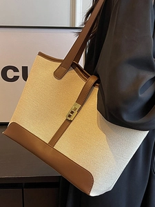 Large beige canvas tote bag with brown leather handles and gold metal lock detail