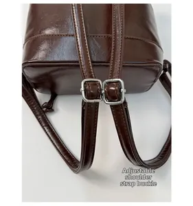 Detail der verstellbaren Metallschnalle am dunkelbraunen Leder-Schultergurt vom Rucksack