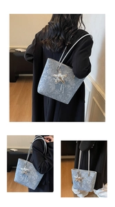 Detail of light blue floral tote bag with silver star pendant and slim shoulder straps