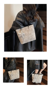 Detail of grey floral tote bag featuring black shoulder straps and star-shaped metal pendant
