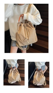Detail of khaki drawstring backpack with orange woven handle and nylon texture
