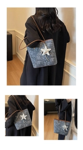 Close-up of gray floral tote bag featuring brown leather straps and star pendant accessory