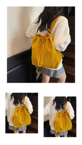 Detail view of the drawstring closure and woven handle on the bright yellow backpack