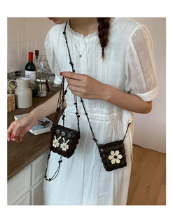 Detail of bohemian mini crossbody bag with shell flower patterns and woven shoulder strap