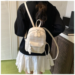 Nahaufnahme des beige-weißen karierten Mini-Rucksacks mit Schultergurten und Textur