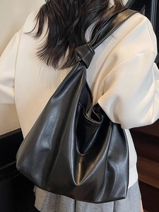 Sac cabas hobo en cuir noir minimaliste avec un nœud en cuir élégant sur la bandoulière