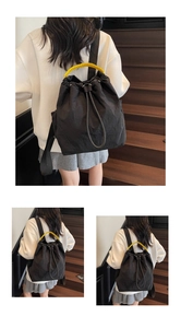 Detail showing high-capacity black drawstring backpack with bright yellow woven handles