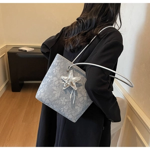 Close-up of light blue floral jacquard tote bag featuring a silver starfish pendant